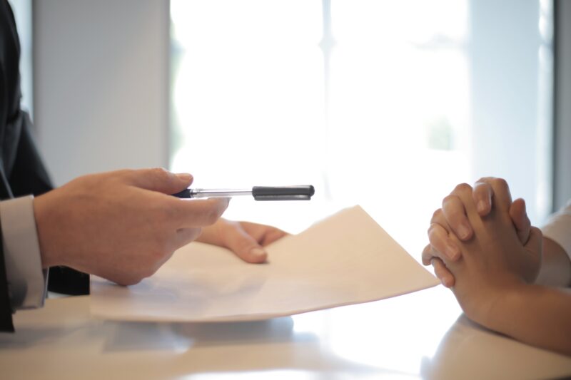 Investment expert handing pen to client.